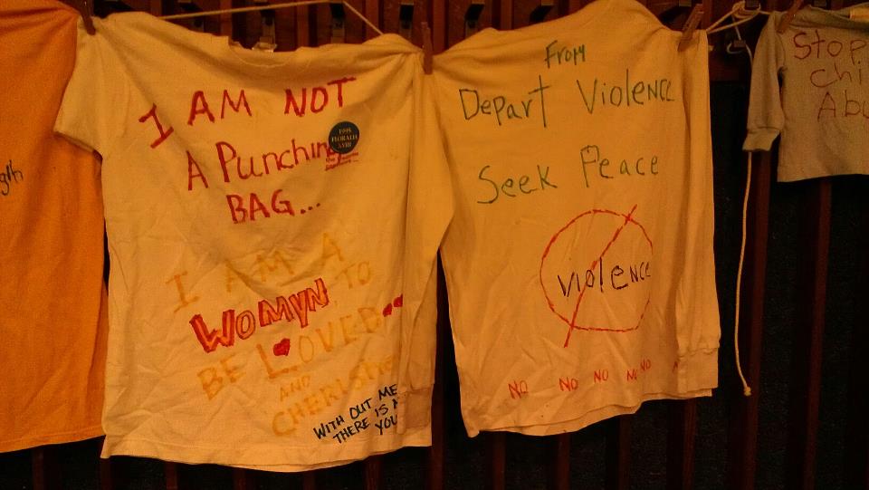 T-shirts with inspirational phrases written on them in colored marker hung from the back wall. Photo by Hannah Nesich.