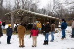 The group of volunteers at the Maple Sugaring Prep Work and Potluck, taking place at the Brook Farm project in New Paltz, NY, gather around farm manager Creek Iverson to participate in the lumberjack song sing a long. Photo by Dawna M. Cservak.