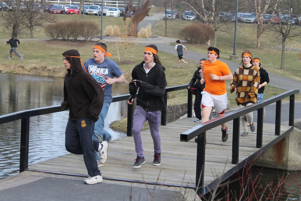 A group of "zombies" chase the "humans" across a bridge over the pond on the SUNY New Paltz campus. Photo by Faith Gimzek.